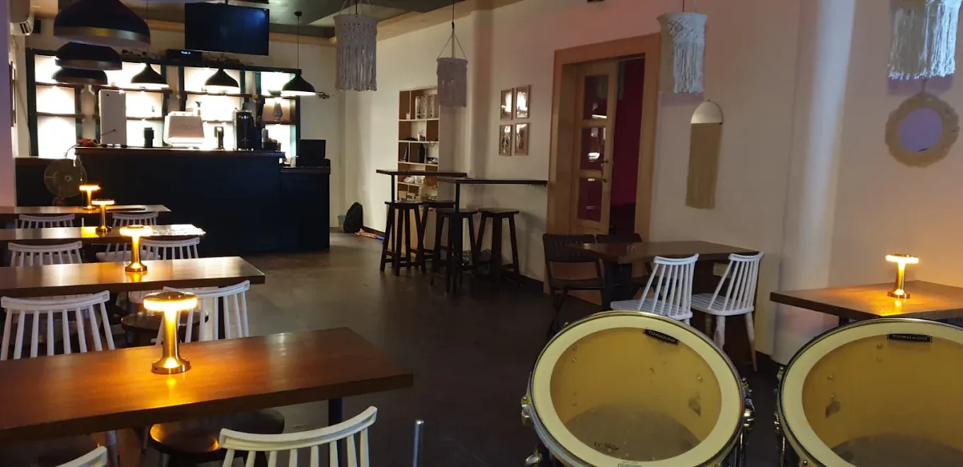 Inside The Highbrooks Cafe: wooden tables, white chairs and warm table lamps